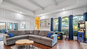 Een moderne woonkamer met een hoekbank, een bijzettafeltje en een boekenkast.