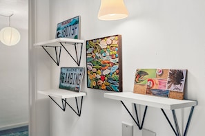 A wall with three shelves displaying various decorative items.