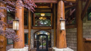 A rustic wooden building with a stone entrance, wooden columns, and a glass door. - Big Bear Lodge at Eagles Nest (Banner Elk)