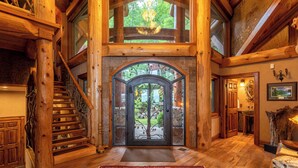 A wooden staircase leading to a glass door with a tree view, a rug, and a wooden floor. - Big Bear Lodge at Eagles Nest (Banner Elk)