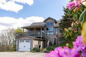 A two-story house with a garage, a balcony, and a well-maintained garden. - Welcome Home (Blowing Rock)