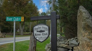 A sign for Eagles Nest River Club with a fish logo and establishment year 2013. - Snowflake River Ridge at Eagles Nest (Banner Elk)