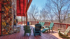 A wooden deck with Adirondack chairs, a stone wall, and a red railing. - Boles Lodge (Boone)