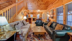 A log cabin interior with a living room, kitchen, and staircase. - 1 Abundant Life (Vilas)