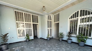 A spacious indoor area with large windows, tiled flooring, and potted plants. - Spacious 2bed & 2bath Villa (Bishofitu)