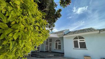 A traditional house with a tiled courtyard, arched windows, and a small outdoor seating area.
