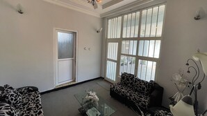 A living room with a sofa, a coffee table, and a chandelier. - Spacious 2bed & 2bath Villa (Bishofitu)