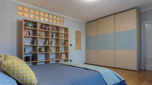 A bedroom with a bed, a bookshelf, and a wardrobe. - Light Blue Apartment by Wonderful Italy (Turin)
