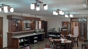 Un restaurant avec des meubles en bois, un coin bar et un sol à motifs.