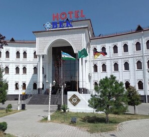 Valkoinen rakennus, jossa on kyltti, jossa lukee ”HOTEL BEK”, ja lippuja.
