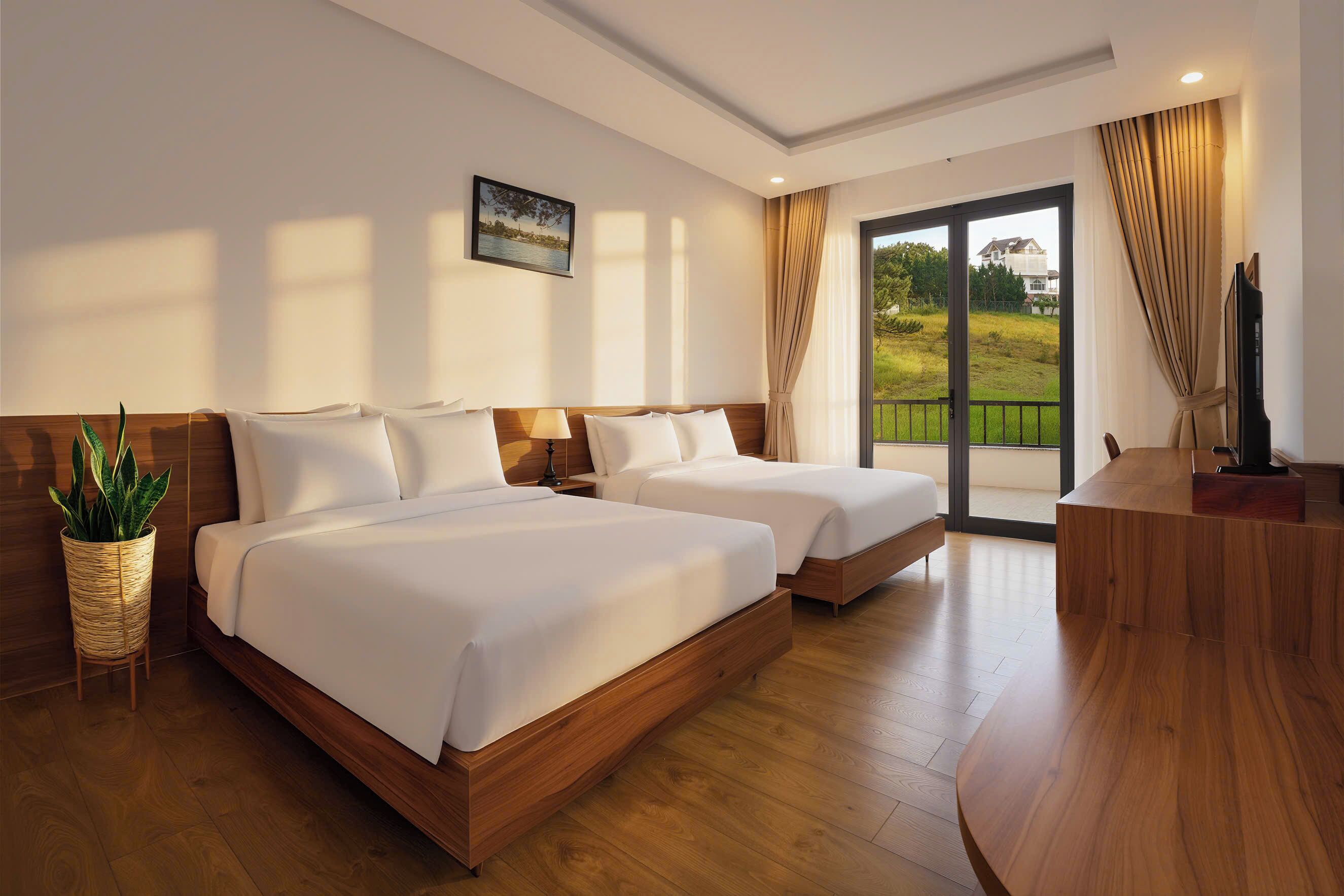 Une chambre d’hôtel avec deux lits, un plancher en bois, une grande fenêtre donnant sur un beau paysage et un téléviseur posé sur un bureau en bois.