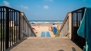 Una escalera junto a la playa que da a una zona arenosa con vista al océano.