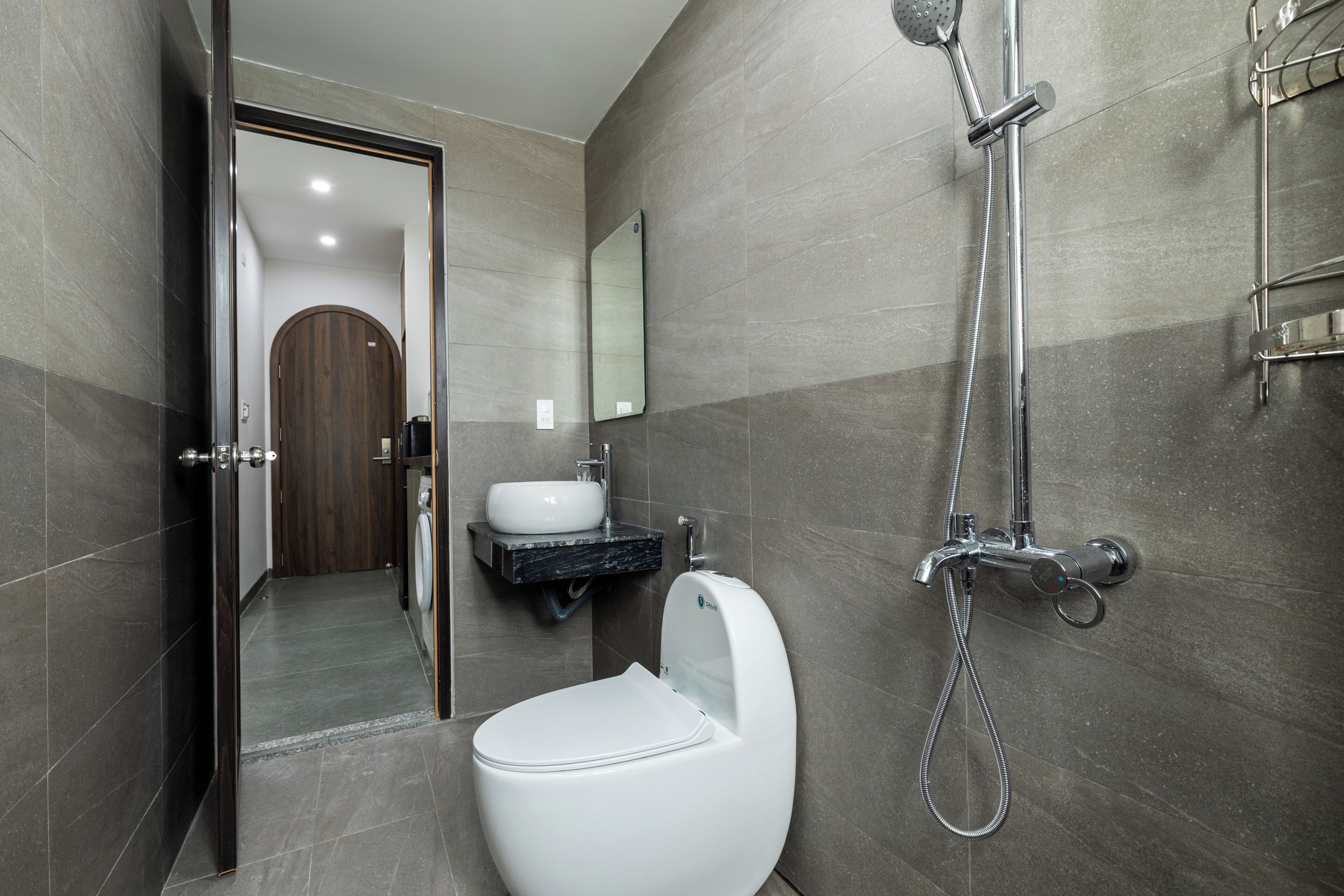 A modern bathroom with a toilet, sink, and shower.