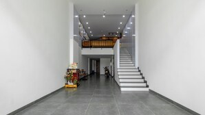 A spacious, modern interior with a staircase leading to an upper level. - Saluton Apartment (Da Nang)