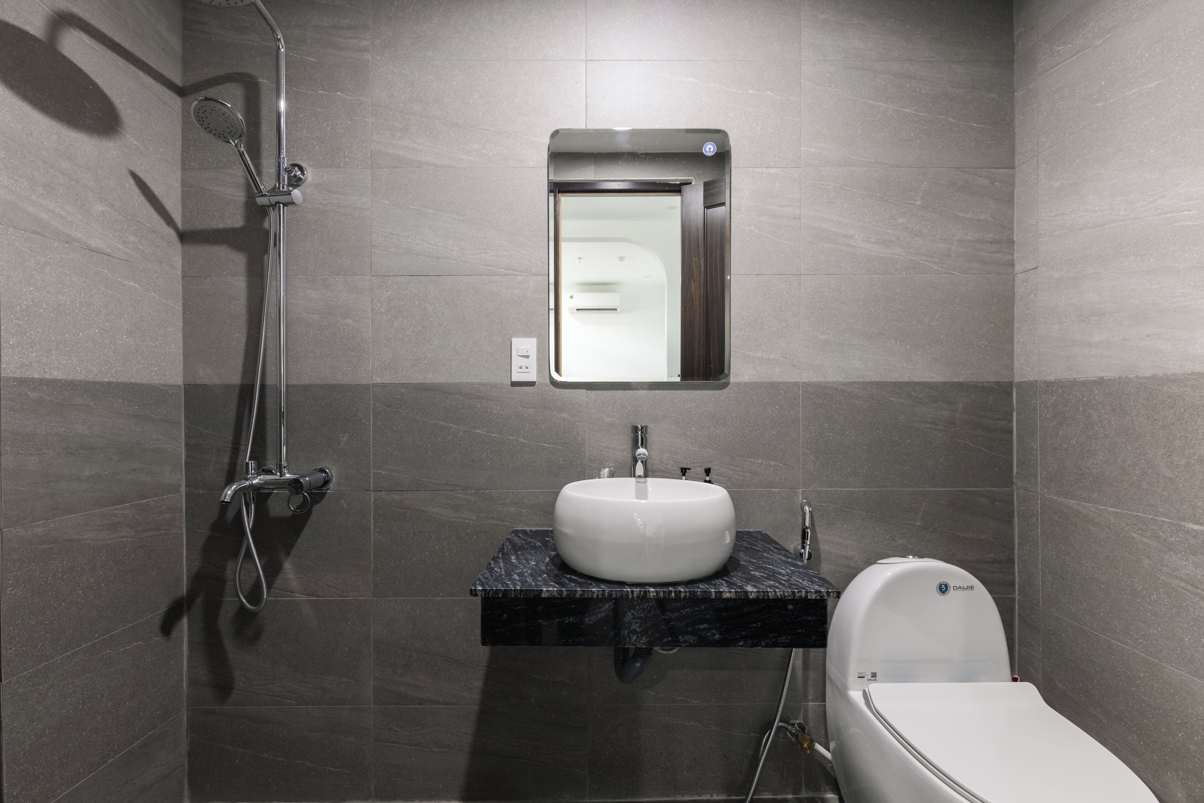 Ein modernes Badezimmer mit Dusche, Waschbecken und Toilette.