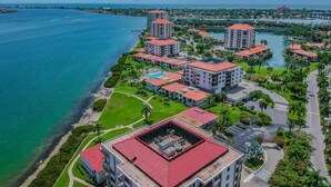 An aerial view of a coastal hotel with multiple buildings, a marina, and a bridge in the background. - 1BR condo with pool, hot tub, kitchen, WiFi, and island views in St. Petersburg. (St. Petersburg)