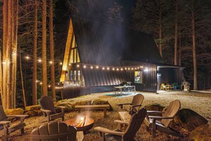 A cabin with a dining area, outdoor seating, and a fire pit. - Two Pines Hollow | Private A-Frame | Hot Tub (Rogers)