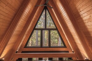 A triangular wooden ceiling with a central window.