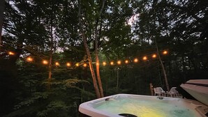 Ein Whirlpool, umgeben von Bäumen mit Lichterketten.
