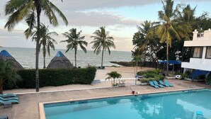 Ein Poolbereich mit Liegestühlen, einem Pool und Blick auf den Ozean.