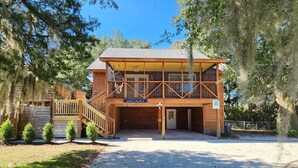 A two-story wooden building with a covered front porch and a sign reading "WACCALAY".