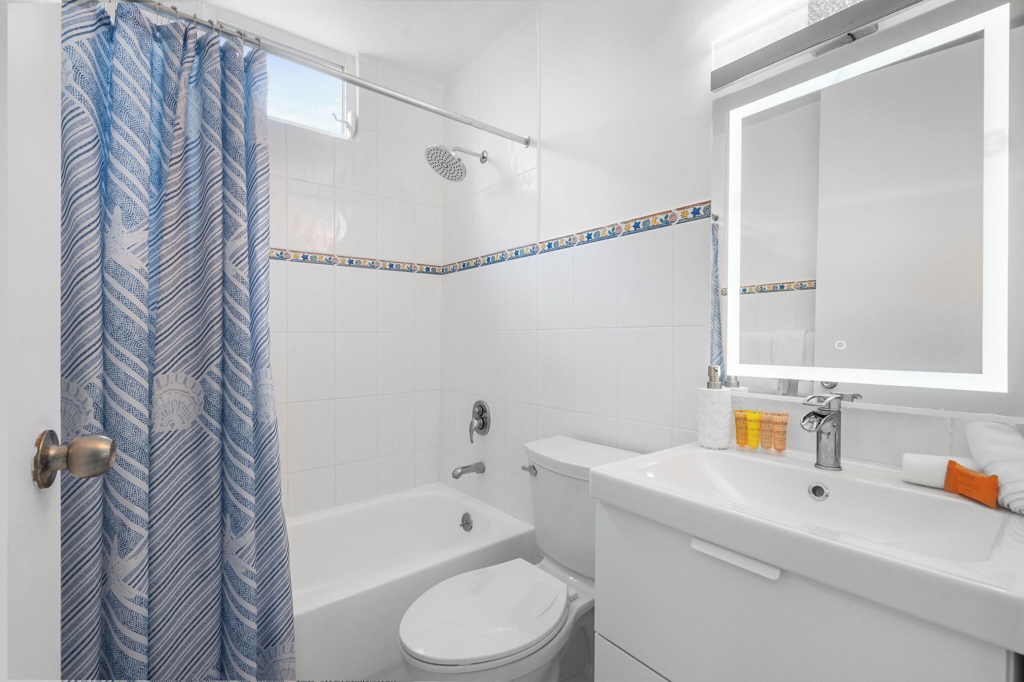 A bathroom with a shower, toilet, and sink.