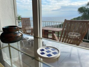 Enjoy the serene sea views from this balcony, featuring a glass table and comfortable seating area.