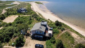 Una proprietà costiera con una grande casa, un patio e vista sulla spiaggia.