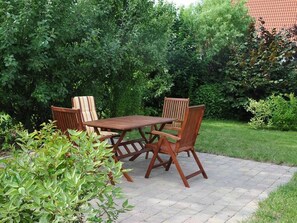 Relax in a serene outdoor space surrounded by lush greenery and comfortable seating.