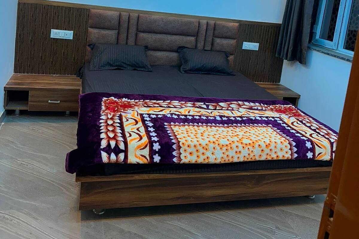 A modern bedroom with a bed, wooden headboard, bedside tables, a ceiling fan, and a window with curtains.