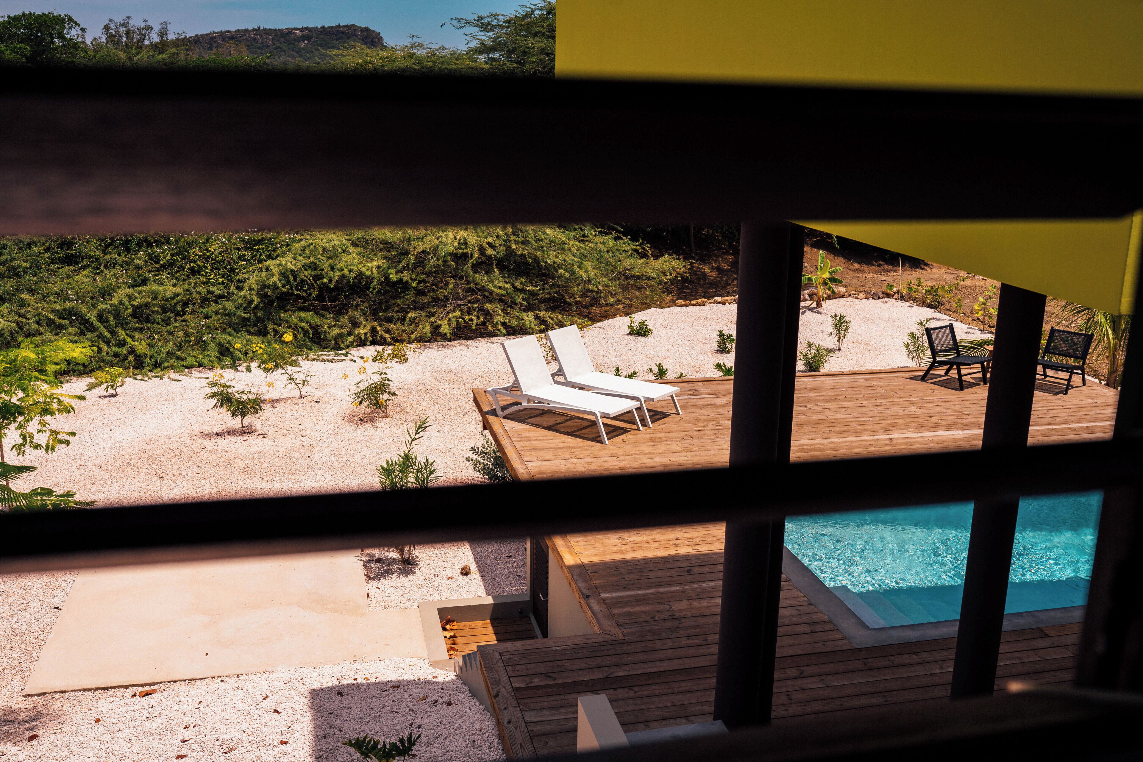 A poolside area with lounge chairs and a wooden deck.