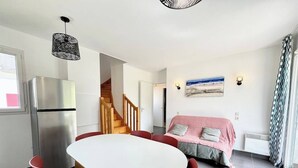 A compact living space with a kitchen, dining area, and a bed. - Maisonnette tout confort - Golf - Piscine (Quéven)