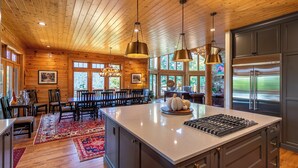 A spacious kitchen with a large island, wooden ceiling, and modern appliances. - A High Country Retreat (Boone)