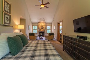 A bedroom with a bed, a television, a fireplace, and a ceiling fan. - Misty Mountain Hop (Blowing Rock)