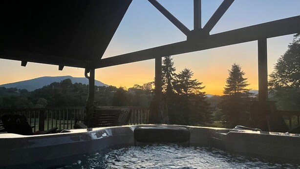 A hot tub with a view of a mountain and trees at sunset. - Robin Hoods Retreat (Jefferson)