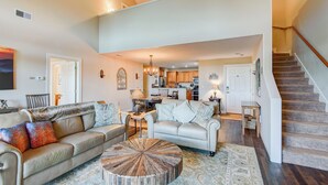 A spacious living room with a high ceiling, a dining area, and a kitchen in the background. - Sugar Sky (Banner Elk)