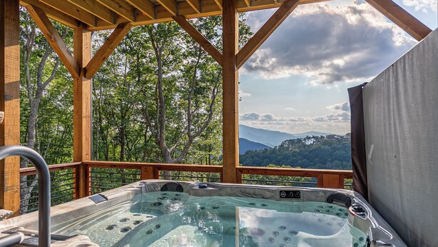 A hot tub with a wooden deck and a scenic mountain view. - Up and Away at Eagles Nest (Banner Elk)