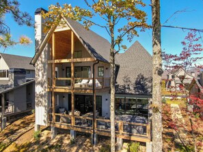 A two-story house with a balcony, large windows, and a chimney. - Blue Meadows at Blue Ridge Mountain (Lenoir)