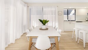 Una cocina moderna con armarios blancos, una encimera blanca y un ventilador de techo.