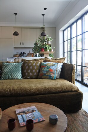 Relax in this inviting living room with a comfortable sofa, coffee table, and kitchen area.