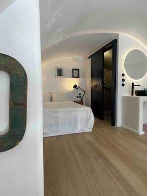 Une chambre à coucher avec un lit, une lampe de chevet et un miroir.