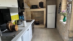 A compact kitchen with white cabinets, a built-in microwave, a toaster, and a refrigerator. - Bâtisse du Xixe, Ranville (Ranville)