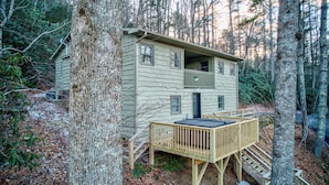 A cabin with a balcony, a deck, and a staircase leading to the entrance. - Orchid Cabin (Banner Elk)
