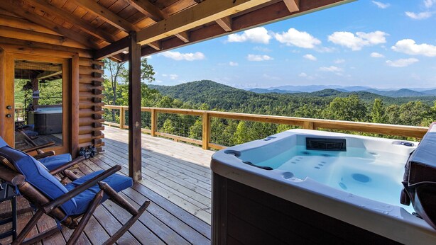 A wooden deck with a hot tub and lounge chairs, overlooking a mountainous landscape. - Come to Escape (Marion)