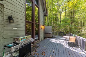A deck with a barbecue grill, outdoor seating, and a hot tub. - The Dog House (Boone)