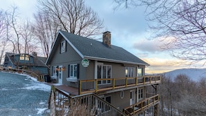 A two-story lodge with a balcony and a stone chimney. - Blue Ridge Vista (Banner Elk)