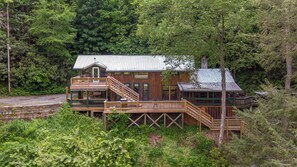 A cabin with a deck, a staircase, and a chimney. - A River Mist (Sugar Grove)