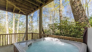 A hot tub on a wooden deck with a view of a forest. - Altitude Adjustment (Banner Elk)