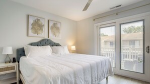 A bedroom with a bed, two bedside lamps, a ceiling fan, and two framed artworks on the wall. - Walk to Shore & Boardwalk: Bethany Beach Retreat (Bethany Beach)