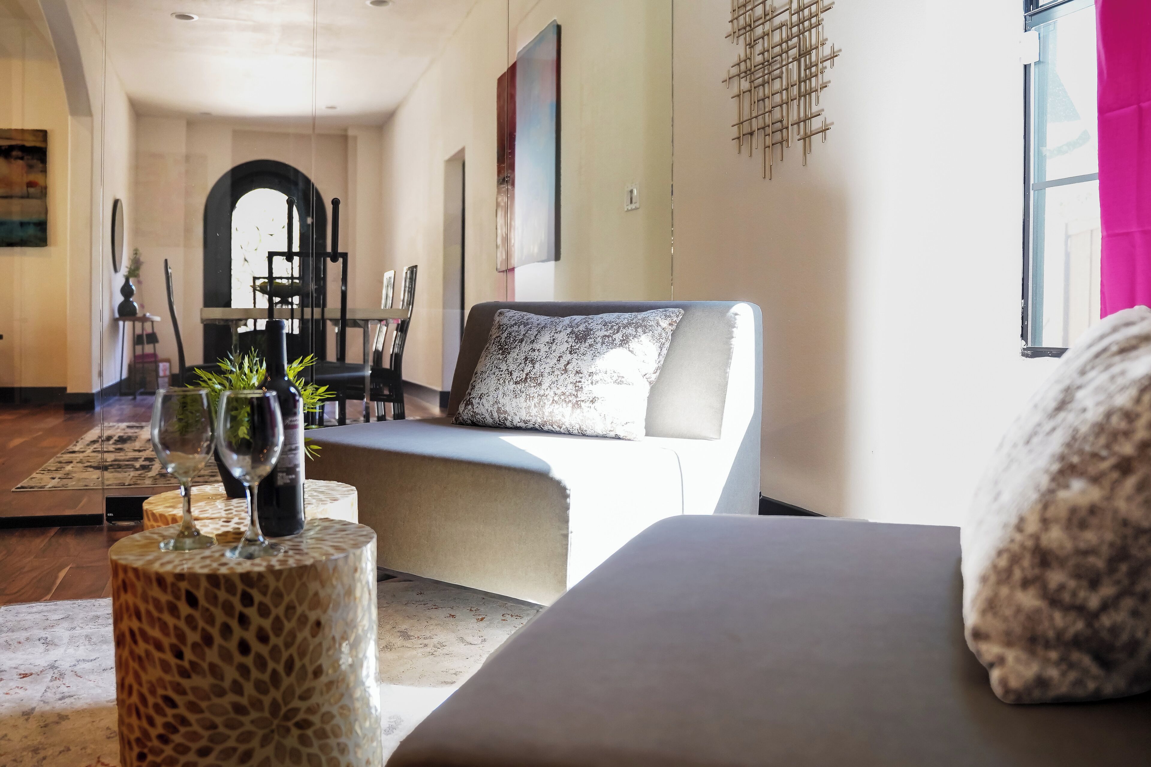 Een moderne woonkamer met een bank, een salontafel en een eethoek op de achtergrond.